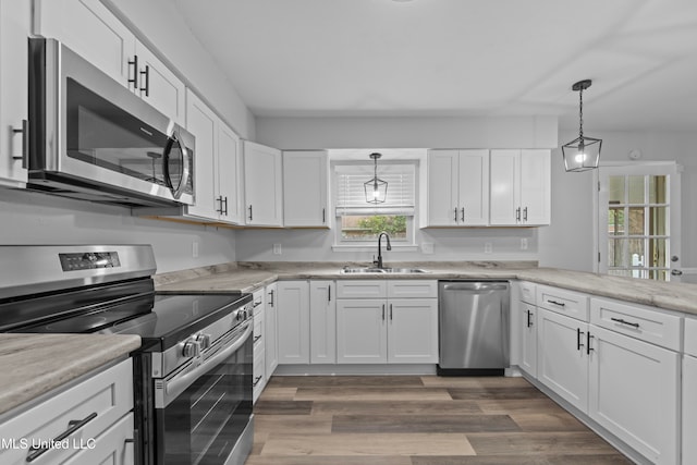 kitchen featuring sink, stainless steel appliances, dark hardwood / wood-style floors, pendant lighting, and white cabinets