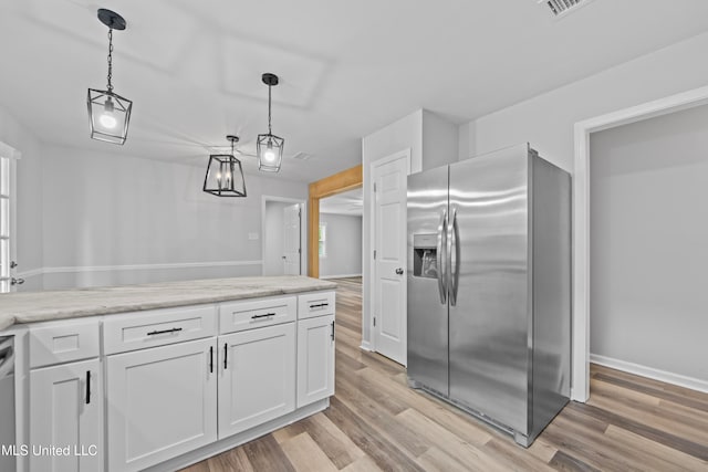 kitchen with light wood-type flooring, stainless steel appliances, white cabinetry, and hanging light fixtures