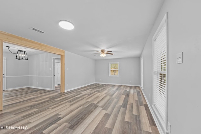 unfurnished room featuring hardwood / wood-style floors and ceiling fan with notable chandelier