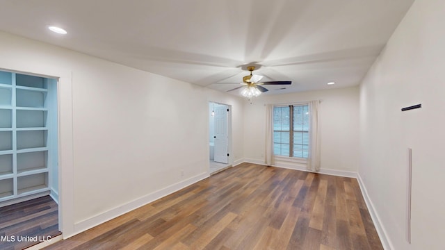 empty room with dark hardwood / wood-style floors and ceiling fan