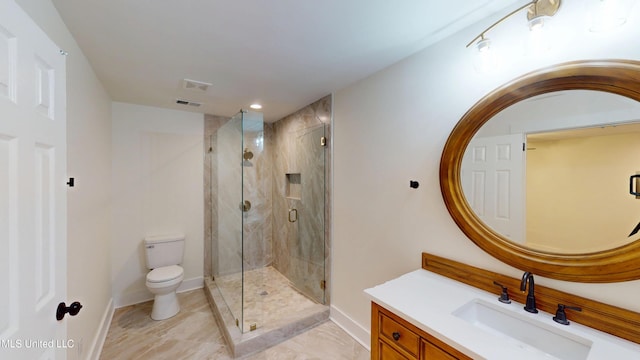 bathroom with vanity, toilet, and a shower with door