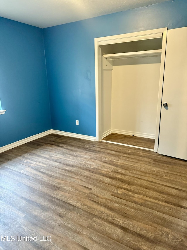 unfurnished bedroom with a closet and hardwood / wood-style floors