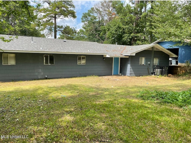 back of property featuring a yard and central air condition unit