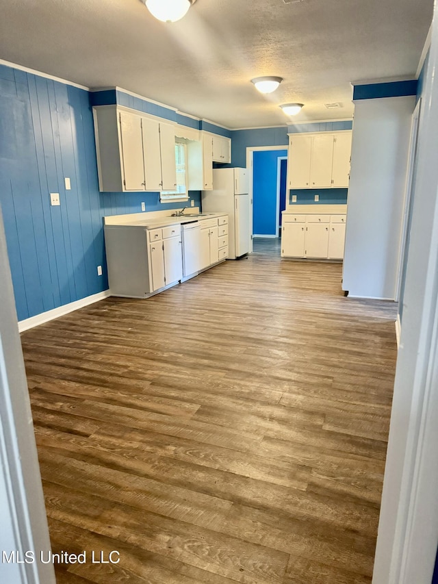 kitchen with sink, light wood-type flooring, white cabinets, a textured ceiling, and white appliances