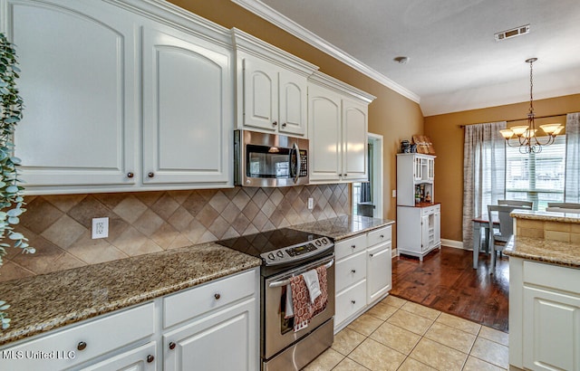 kitchen with stainless steel appliances, an inviting chandelier, light hardwood / wood-style flooring, white cabinets, and pendant lighting