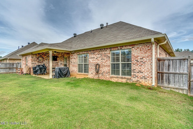 back of property featuring a patio and a lawn