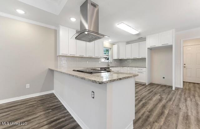 105 Leigh Cir, Ocean Springs, MS 39564 - kitchen featuring island range hood, black electric cooktop, a peninsula, dark wood-type flooring, and white cabinets