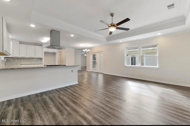 105 Leigh Cir, Ocean Springs, MS 39564 - unfurnished living room with a tray ceiling, dark wood-style flooring, ceiling fan, recessed lighting, and a chandelier