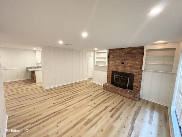 116 Victoria Cir, Newton, MS 39345 - unfurnished living room with light wood finished floors, a decorative wall, built in shelves, recessed lighting, and baseboards
