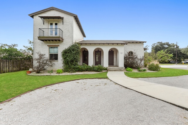 31 Poplar Cir, Gulfport, MS 39507 - mediterranean / spanish-style home featuring a front lawn, a balcony, stucco siding, and fence