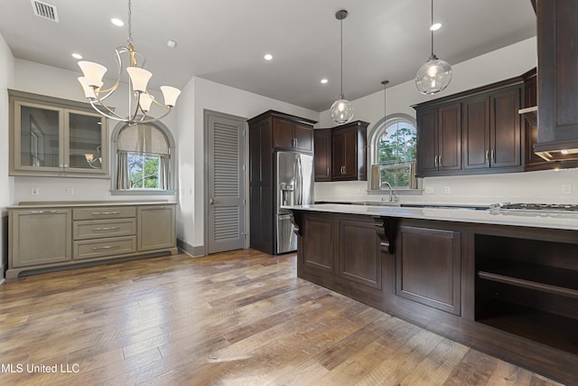 kitchen with pendant lighting, a healthy amount of sunlight, hardwood / wood-style floors, and appliances with stainless steel finishes