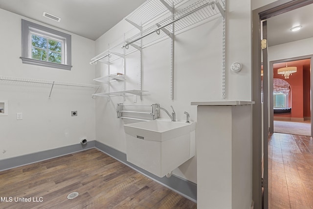 washroom featuring hookup for an electric dryer, plenty of natural light, and dark wood-type flooring