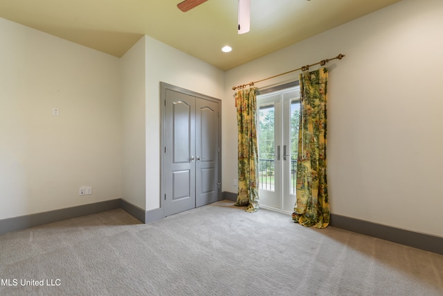 unfurnished bedroom featuring ceiling fan, light colored carpet, and a closet