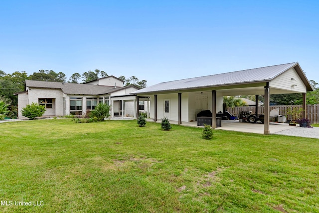 rear view of property with a yard and a carport