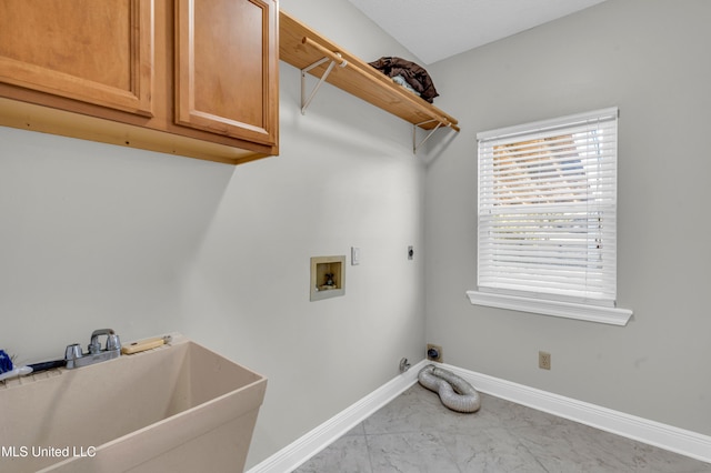 washroom featuring electric dryer hookup, sink, hookup for a washing machine, light tile patterned floors, and cabinets