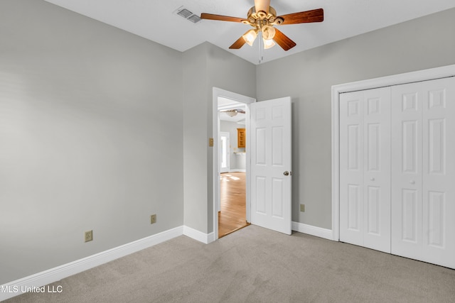 unfurnished bedroom featuring a closet, ceiling fan, and light carpet