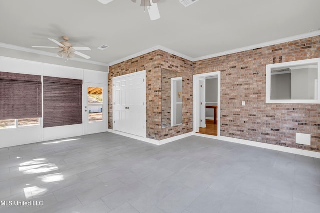 empty room with ceiling fan, brick wall, and ornamental molding