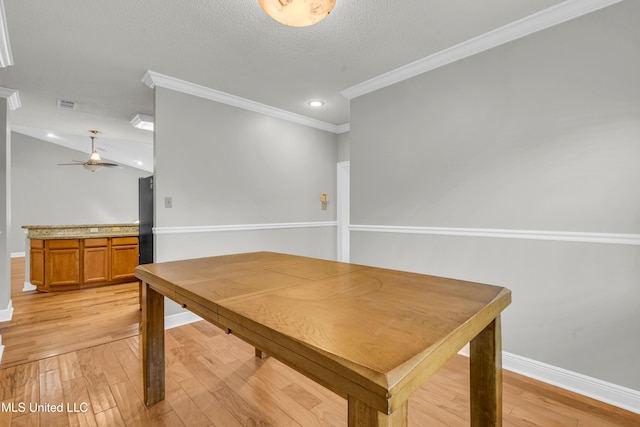 dining area featuring ceiling fan, light hardwood / wood-style floors, a textured ceiling, and crown molding