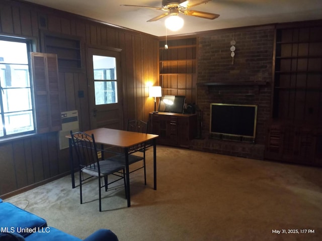 751 Dorgan St, Jackson, MS 39204 - carpeted dining space featuring healthy amount of natural light, wooden walls, a ceiling fan, and a fireplace