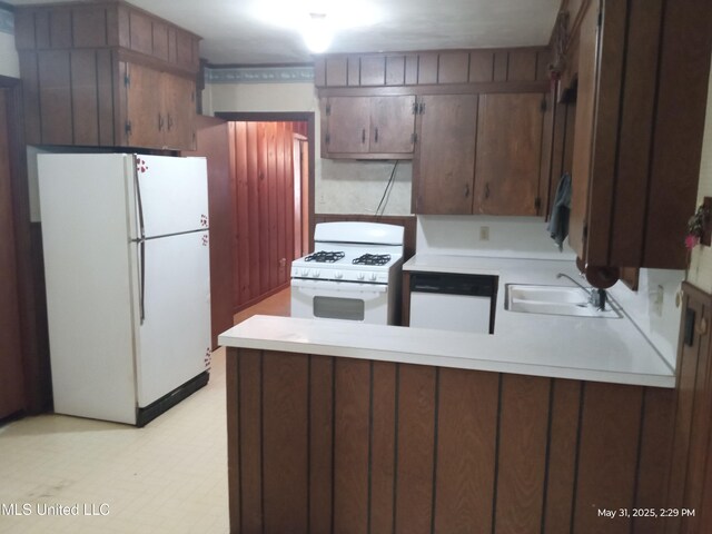 751 Dorgan St, Jackson, MS 39204 - kitchen with white appliances, a peninsula, a sink, and light countertops
