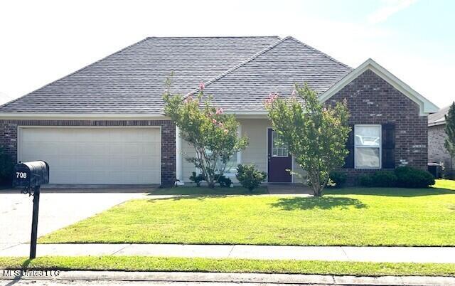 708 Bo Blaze Cv, Brandon, MS 39047 - view of front of home with brick siding, an attached garage, driveway, a front yard, and a shingled roof