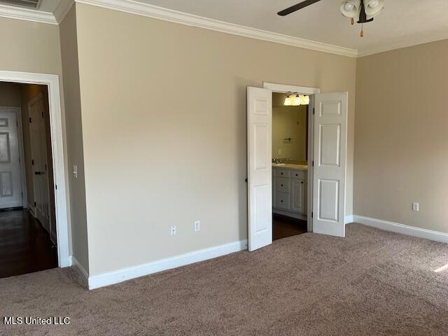 708 Bo Blaze Cv, Brandon, MS 39047 - unfurnished bedroom featuring dark carpet, crown molding, baseboards, and connected bathroom