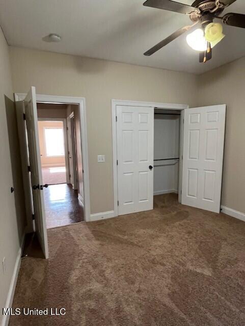 708 Bo Blaze Cv, Brandon, MS 39047 - unfurnished bedroom featuring carpet floors, baseboards, a closet, and a ceiling fan