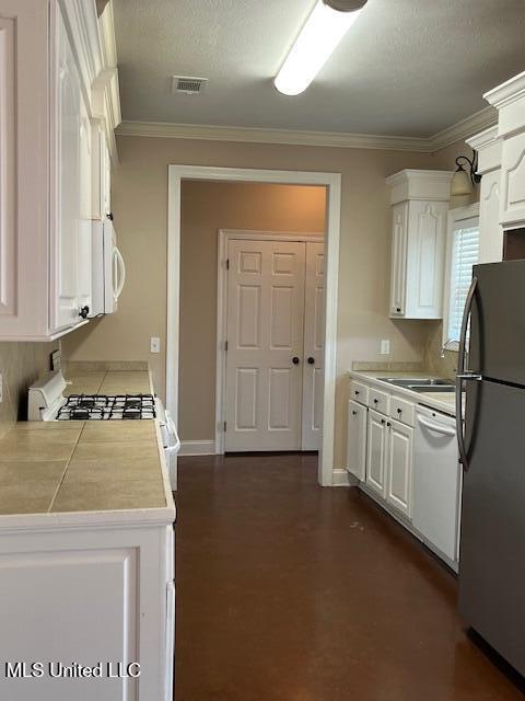 708 Bo Blaze Cv, Brandon, MS 39047 - kitchen featuring white appliances, white cabinetry, ornamental molding, a sink, and baseboards