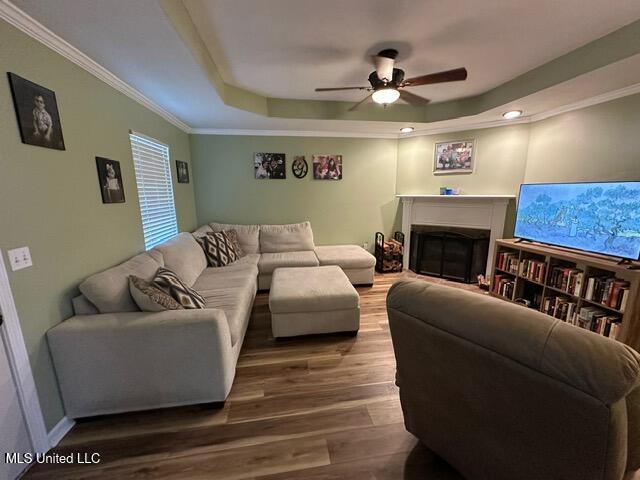 133 Windchase, Brandon, MS 39042 - living area with a raised ceiling, wood finished floors, ceiling fan, a fireplace, and ornamental molding