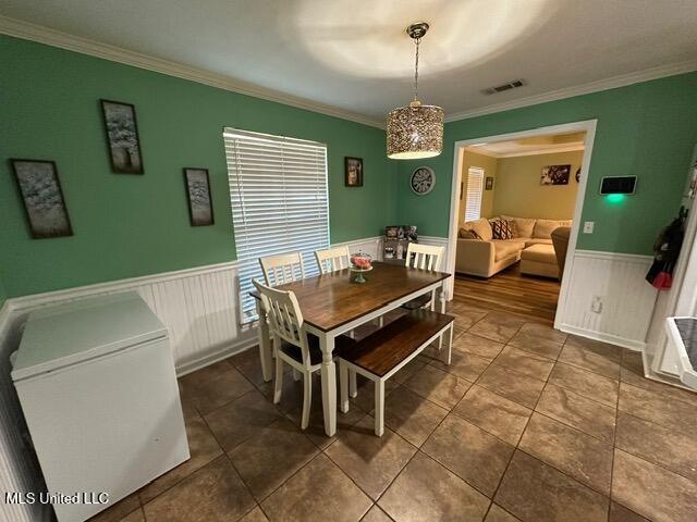 133 Windchase, Brandon, MS 39042 - dining space with a wainscoted wall, crown molding, and dark tile patterned flooring