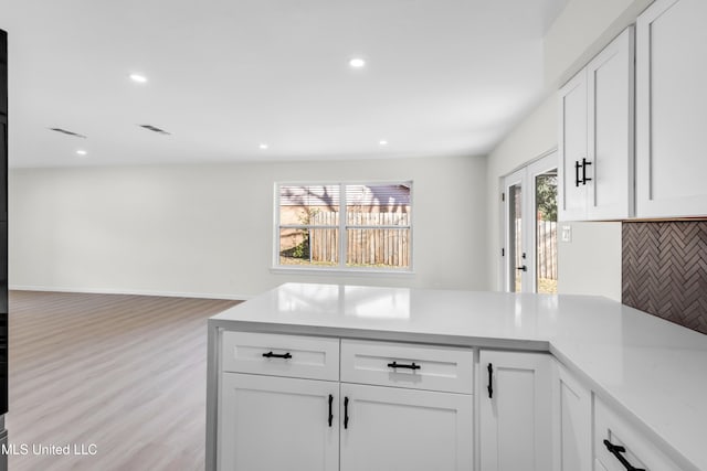 kitchen with visible vents, white cabinets, light countertops, backsplash, and recessed lighting