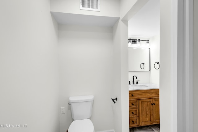 bathroom featuring toilet, visible vents, and vanity