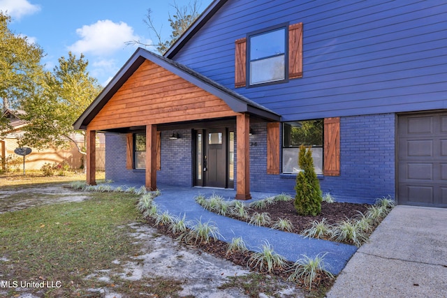 view of front of home featuring a garage, covered porch, and brick siding