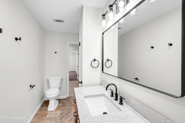 bathroom with visible vents, vanity, toilet, and baseboards