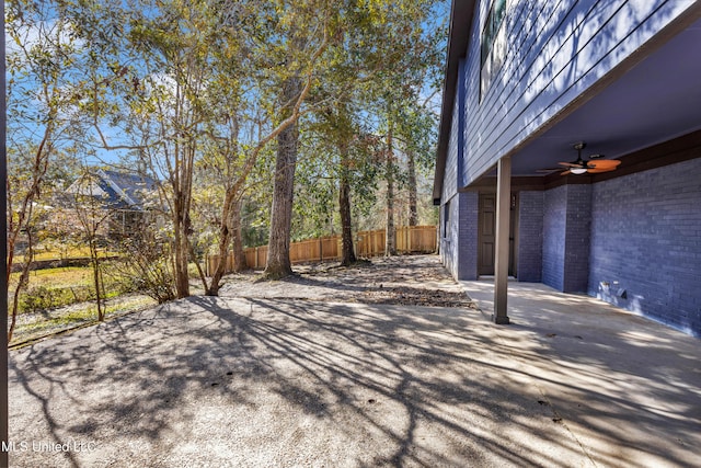 view of patio / terrace with ceiling fan and fence