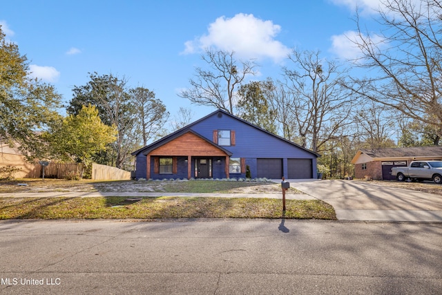 view of front of home featuring brick siding, fence, driveway, and an attached garage