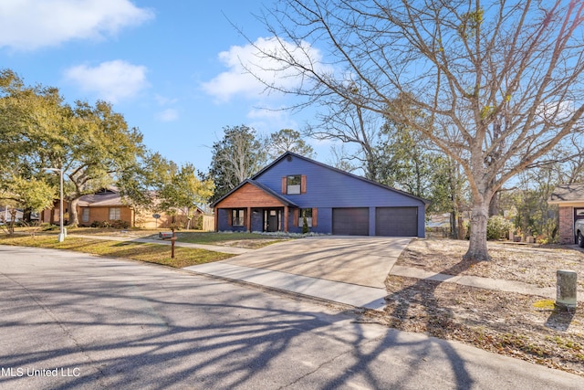 view of front of home featuring a garage, a front yard, and driveway