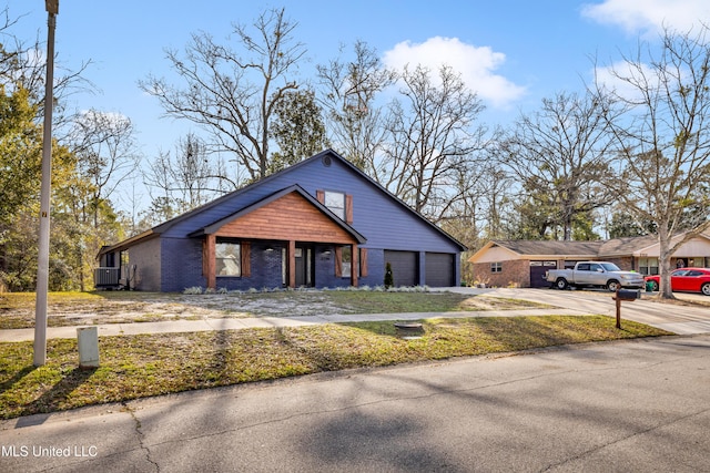 view of front of property featuring brick siding, driveway, central AC, and an attached garage