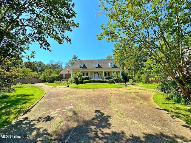 cape cod home with a front yard and a porch