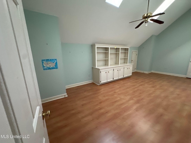 interior space with ceiling fan, light hardwood / wood-style flooring, and lofted ceiling with skylight