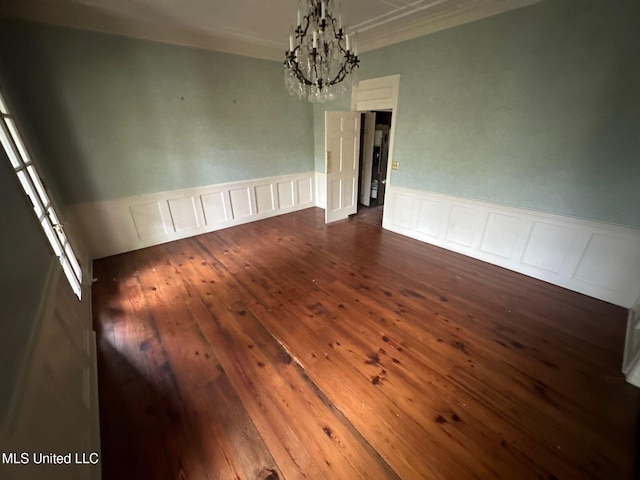 unfurnished dining area featuring ornamental molding, dark hardwood / wood-style flooring, and a notable chandelier