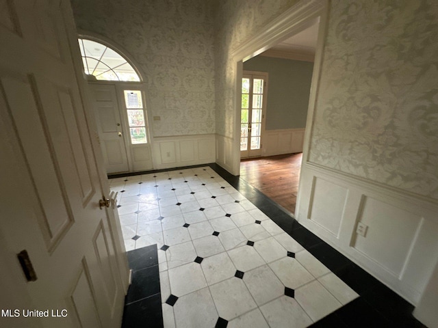 foyer featuring light hardwood / wood-style floors and crown molding