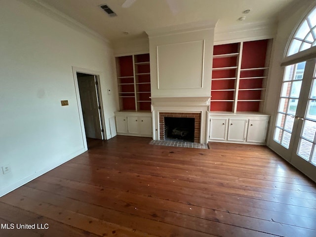 unfurnished living room with a brick fireplace, wood-type flooring, and french doors