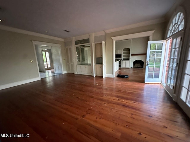 unfurnished living room with crown molding and dark hardwood / wood-style flooring