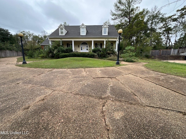 new england style home with a front lawn and covered porch