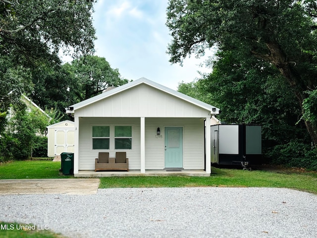 1045 Mckinley St, Waveland, MS 39576 - bungalow featuring a storage unit, covered porch, and board and batten siding