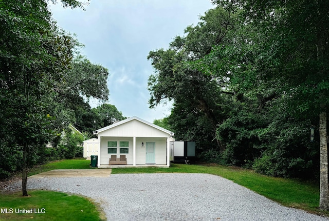 1045 Mckinley St, Waveland, MS 39576 - bungalow-style home with gravel driveway, a front yard, covered porch, and a storage shed
