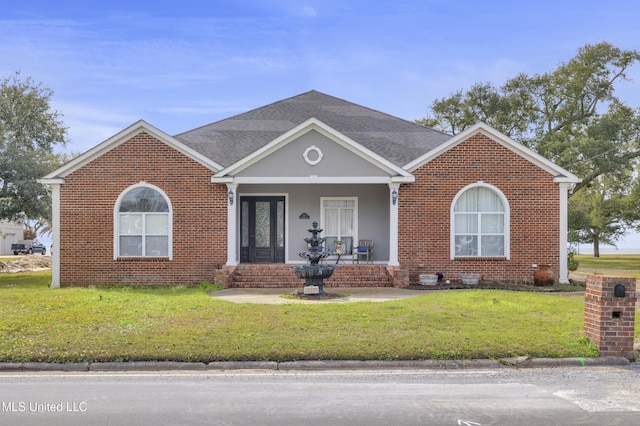 view of front facade with brick siding, a shingled roof, and a front lawn