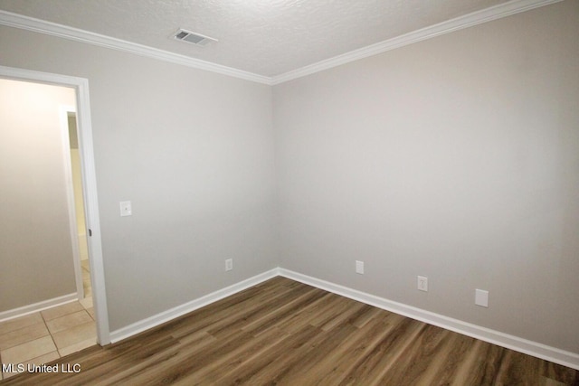 unfurnished room with visible vents, crown molding, wood finished floors, baseboards, and a textured ceiling