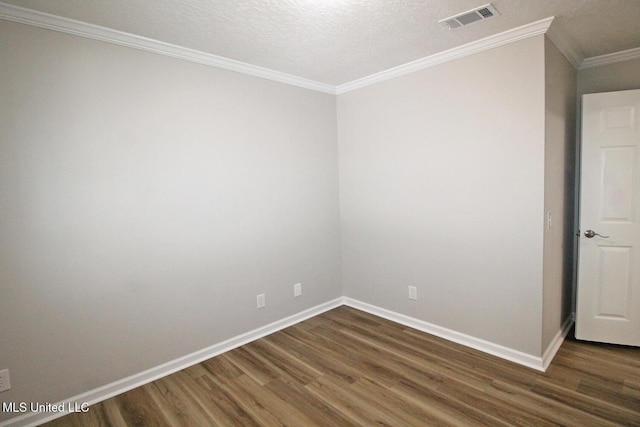 spare room featuring crown molding, baseboards, visible vents, and wood finished floors